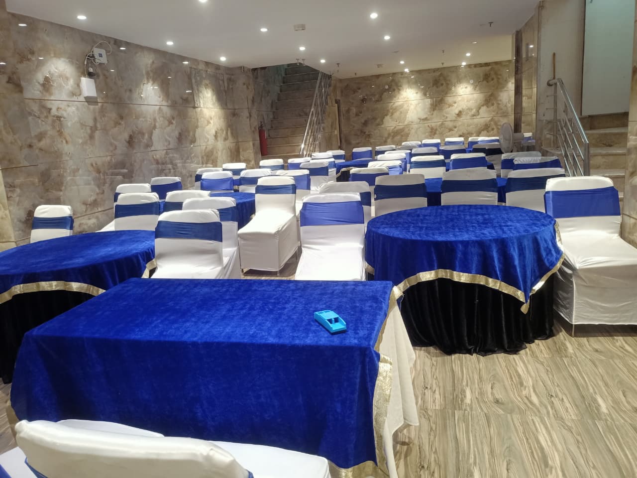 Hall 2 arranged for a training with blue-draped banquet tables and covered seating
